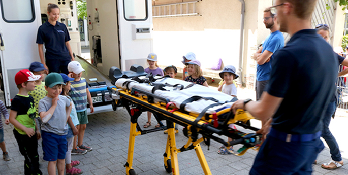 Casa-Kinder besichtigen einen Rettungswagen